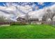 Large green backyard with a wood fence, surrounding trees, and the home exterior at 7425 S Dexter St, Centennial, CO 80122