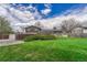 Expansive backyard featuring a lush lawn, mature trees, and a charming wooden fence for added privacy at 7425 S Dexter St, Centennial, CO 80122