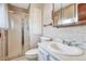 Bathroom featuring tiled floors and walls, a shower with a glass door, vanity sink, and toilet at 7425 S Dexter St, Centennial, CO 80122
