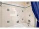Tiled bathtub and shower, with a blue shower curtain at 7425 S Dexter St, Centennial, CO 80122