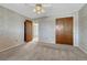 Carpeted bedroom featuring neutral-toned walls, a double closet, a ceiling fan with lighting, and an open door at 7425 S Dexter St, Centennial, CO 80122