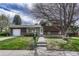 Charming two-story home with a well-maintained front yard, walkway, and wood facade under a partly cloudy sky at 7425 S Dexter St, Centennial, CO 80122