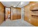 Hallway with wood paneling, carpeted floors, and doorways leading to other rooms at 7425 S Dexter St, Centennial, CO 80122