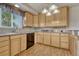 Classic kitchen featuring wood cabinets, tile backsplash, stainless steel sink, and modern appliances at 7425 S Dexter St, Centennial, CO 80122