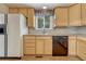 Functional kitchen with ample wooden cabinets, tile backsplash, laminate flooring, and modern appliances at 7425 S Dexter St, Centennial, CO 80122