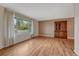 Bright living room with hardwood floors, large window with sheer curtains, and an antique wood hutch at 7425 S Dexter St, Centennial, CO 80122