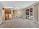 Large living room with sliding doors to the patio, carpeting, and access to stairs at 7425 S Dexter St, Centennial, CO 80122