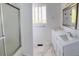 Bright bathroom featuring double sinks, marble floors, and a glass-enclosed shower at 12225 E 2Nd Dr, Aurora, CO 80011
