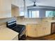 Bright kitchen with white cabinets, modern appliances, and views of the living area at 12225 E 2Nd Dr, Aurora, CO 80011