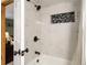 Bright bathroom featuring white marble tile and black fixtures in the shower and tub at 12476 W Nevada Pl # 106, Lakewood, CO 80228