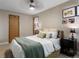 Bright bedroom showcasing a queen-sized bed with wood door and neutral toned walls at 12476 W Nevada Pl # 106, Lakewood, CO 80228
