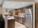 This kitchen features warm wood cabinets, tile floor, stainless steel appliances, and a window for natural light at 12476 W Nevada Pl # 106, Lakewood, CO 80228