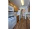 Efficient kitchen featuring white appliances, wooden cabinets, and easy access to the adjacent laundry area at 8791 Chase Dr # 220, Arvada, CO 80003