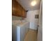 Functional laundry room with a washer and dryer, overhead cabinets, and linoleum flooring at 8791 Chase Dr # 220, Arvada, CO 80003