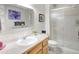 Bright bathroom with white shower, tile floor, wood vanity, and decorative mirror and lighting at 18399 Wagon Trl, Mead, CO 80542