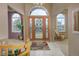Bright foyer showcasing a decorative glass front door, tile floors, and arched windows at 18399 Wagon Trl, Mead, CO 80542