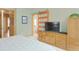 Main bedroom boasts a large dresser, TV, and a view of the main bath at 18399 Wagon Trl, Mead, CO 80542