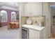 Charming wet bar with beverage cooler, stylish backsplash, and elegant dining room view at 18399 Wagon Trl, Mead, CO 80542