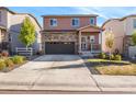 Two-story home with stone accents, neutral paint, and a well-maintained front yard and concrete driveway at 1914 Villageview Ln, Castle Rock, CO 80104