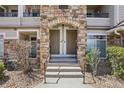 Close-up of a townhouse entrance featuring stone archways, dual doors, and a concrete stoop at 12711 Colorado Blvd # 1009, Thornton, CO 80241