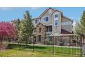 Attractive multi-story townhome featuring stone accents and a secure, modern wrought iron fence at 12711 Colorado Blvd # 1009, Thornton, CO 80241