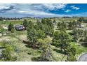 Expansive aerial view of a home nestled amongst mature trees in a serene, sprawling landscape at 10534 Inspiration Dr, Parker, CO 80138