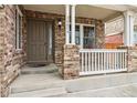 Close up shot of front door and covered porch with railing and steps at 20875 E Girard Pl, Aurora, CO 80013