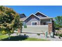 Back of single-Gathering home featuring a cozy outdoor space, stone accents, and well-maintained landscaping at 12940 Jasmine St # A, Thornton, CO 80602