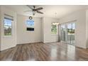 Bright living room featuring hardwood floors, large windows, and sliding glass doors to the outside at 12940 Jasmine St # A, Thornton, CO 80602