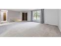 Bright living room with neutral walls, staircase and plush carpeting at 9134 Bellaire St, Thornton, CO 80229