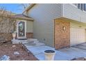 Close-up of the front door, complemented by landscaped steps and attractive brick accents at 8210 Hoyt Ct, Arvada, CO 80005