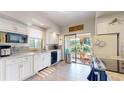 Bright kitchen featuring white cabinetry, tile backsplash, stainless steel appliances, and sliding door to outside at 2545 N State Highway 67, Sedalia, CO 80135