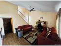 Bright living room featuring hardwood floors, a staircase, and comfortable seating at 4677 S Salida St, Aurora, CO 80015