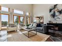 Bright living room boasts large windows, a cozy seating arrangement, and views of the landscape at 8544 Burning Tree Trl, Franktown, CO 80116