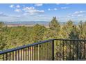 Scenic view from the balcony, featuring lush green trees and majestic mountains in the distance at 8544 Burning Tree Trl, Franktown, CO 80116