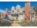 Charming townhome with gray siding, brick chimney, manicured lawn, and inviting front entrance at 8391 W 90Th Pl, Westminster, CO 80021