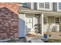 Inviting front porch with brick accent, potted plants, and welcome mat at 8391 W 90Th Pl, Westminster, CO 80021