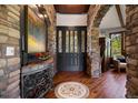 Grand foyer with stone archways, hardwood floors, mosaic rug, and a gorgeous black door with glass panels at 3216 Country Club Pkwy, Castle Rock, CO 80108