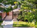 Charming bungalow-style home with manicured lawn, driveway, and a brick-accented entryway, plus mature trees at 3739 W 46Th Ave, Denver, CO 80211