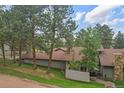 Two-story home with beautiful trees, fenced patio, and stone chimney at 2378 Hearth Dr # 20, Evergreen, CO 80439