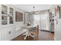 Bright dining room with a white table set, modern chandelier, and built-in cabinet at 10810 W Alamo Pl, Littleton, CO 80127