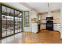 White kitchen cabinets, black appliances, and parquet floors at 1530 S Quebec Way # 24, Denver, CO 80231