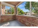 Cozy enclosed front porch with brick detailing and a view of the surrounding neighborhood at 521 Harrison St, Denver, CO 80206