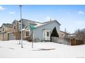 Two-story house with gray siding, visible street address and snowy yard at 4072 S Kirk Way, Aurora, CO 80013