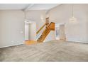 Bright living room with vaulted ceiling, hardwood floors, and a staircase at 4072 S Kirk Way, Aurora, CO 80013