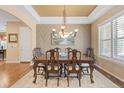 Elegant dining room with hardwood floors, decorative chandelier, and a large window for natural light at 10182 Bristleridge St, Parker, CO 80134