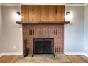 Close-up of the brick fireplace with a wood mantel and hearth at 10025 W 8Th Ave, Lakewood, CO 80215
