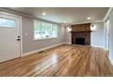 Inviting living room featuring beautiful hardwood floors and a cozy brick fireplace with a wooden mantle at 10025 W 8Th Ave, Lakewood, CO 80215