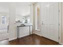 Bright foyer with hardwood floors, a modern console table, and views into the living area at 7367 S Pennsylvania St, Littleton, CO 80122