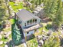 Aerial view of property showcasing the architecture and surrounding landscape with mature trees at 22155 Cook Ln, Morrison, CO 80465